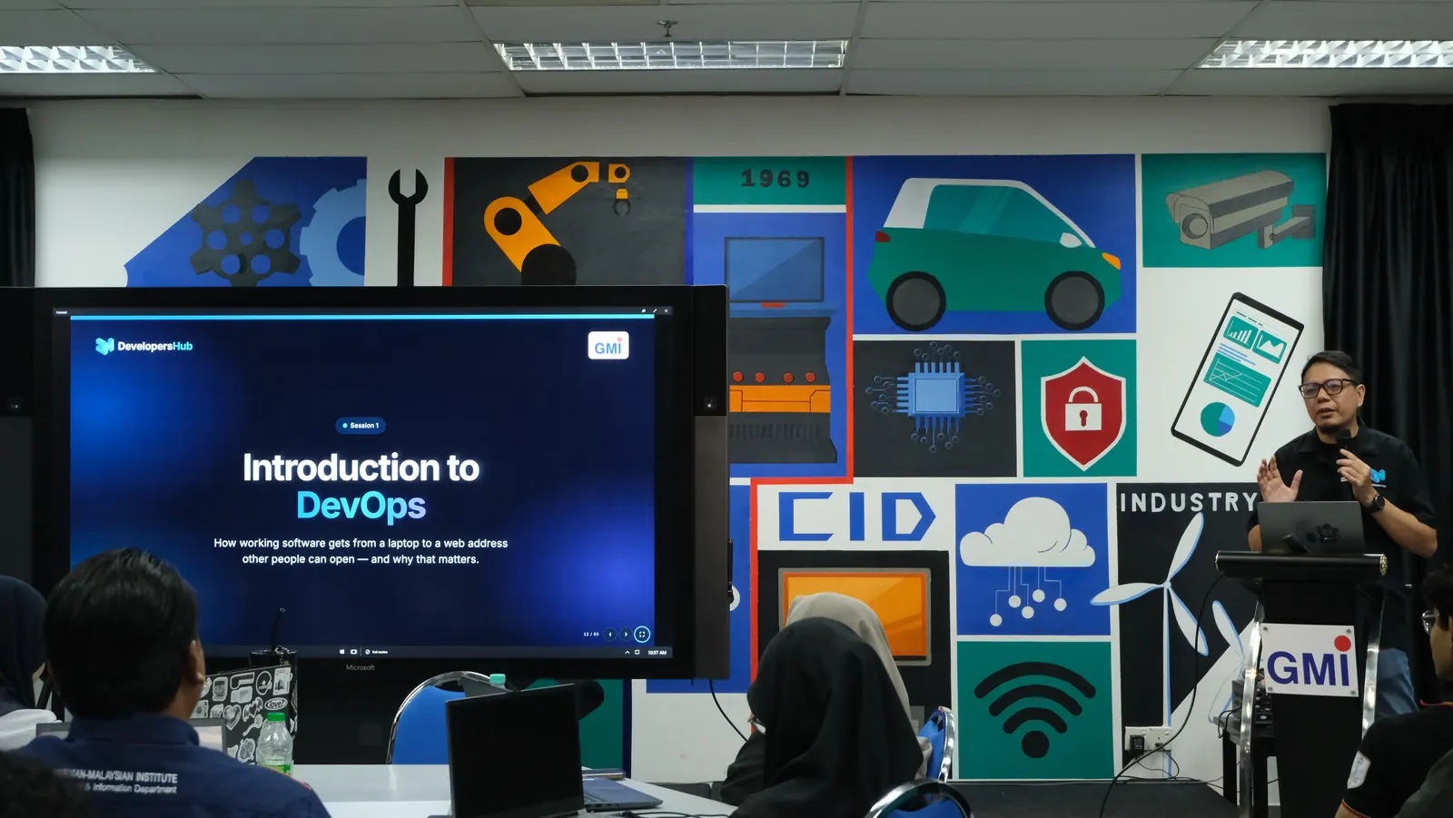 Nasrul Hazim presenting Introduction to DevOps, with the session title on the screen