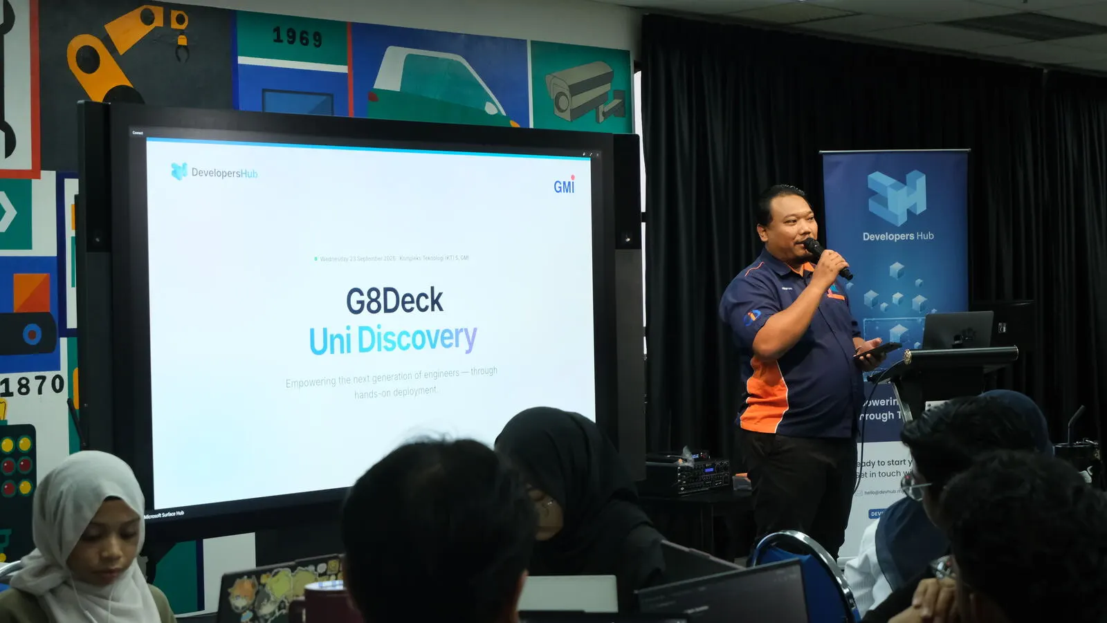 A presenter opens G8Deck Uni Discovery in front of a projected title slide